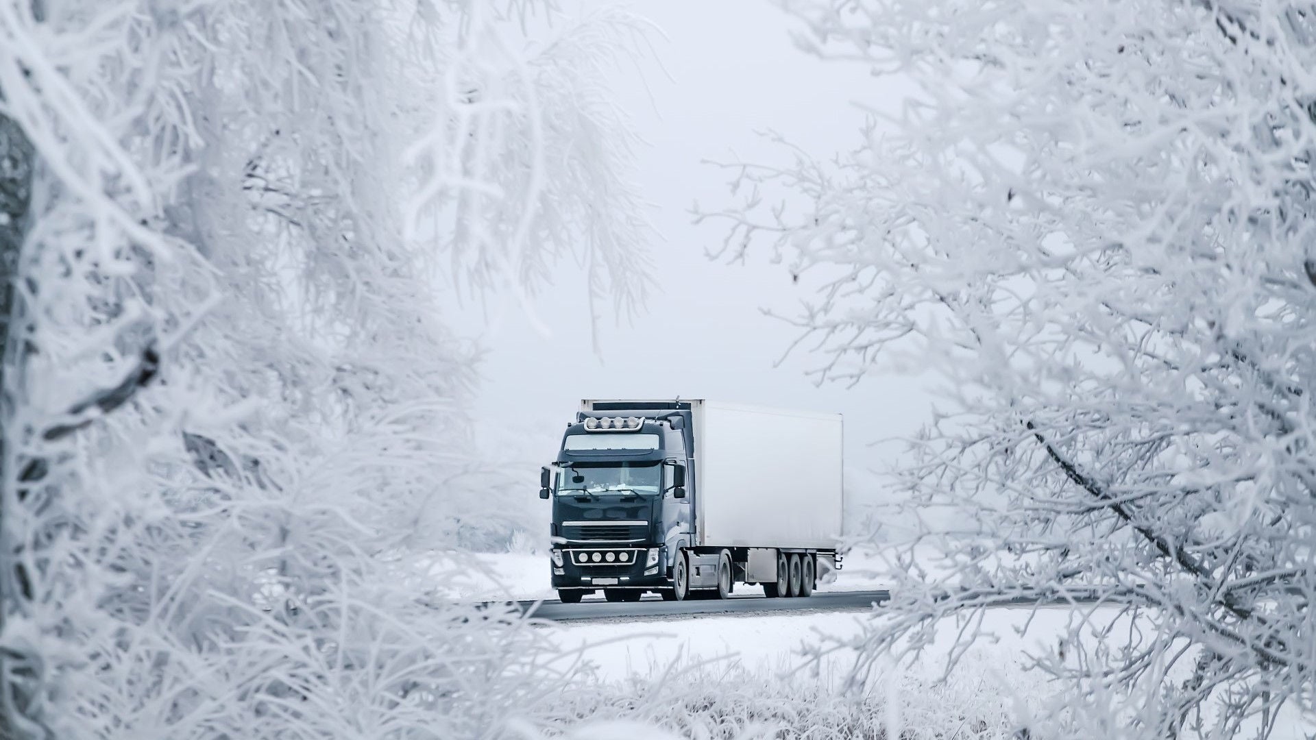 Truck driving through winter landscape