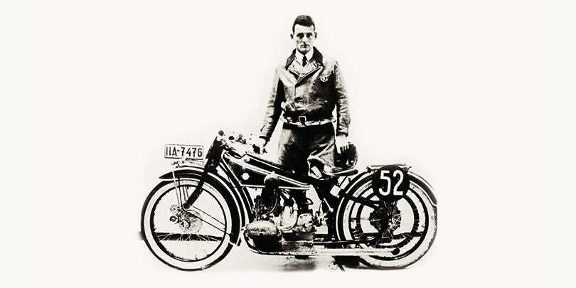 Mann steht neben einem Motorrad