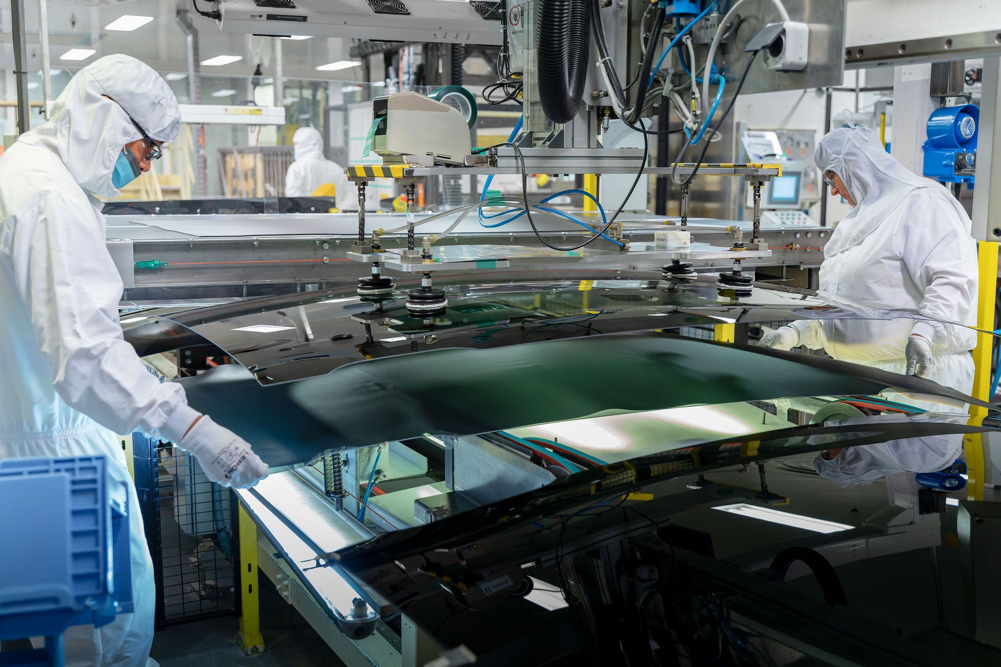 Belt workers place glass in openable roof system