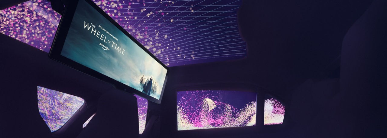 BMW-Innenraum mit großformatigem Theaterscreen im Dach und animierten Fenstern, unterstreicht Webasto als Systempartner für Dach-Displays im Pressebereich.