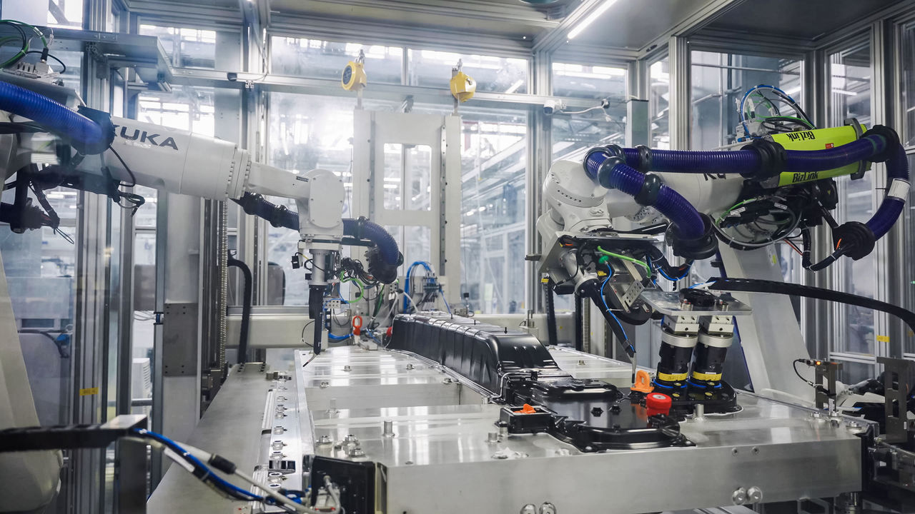 Robotic assembly cell applying automated fastening, sealing and inspection to an EV HV battery pack, demonstrating Webasto's battery systems production.