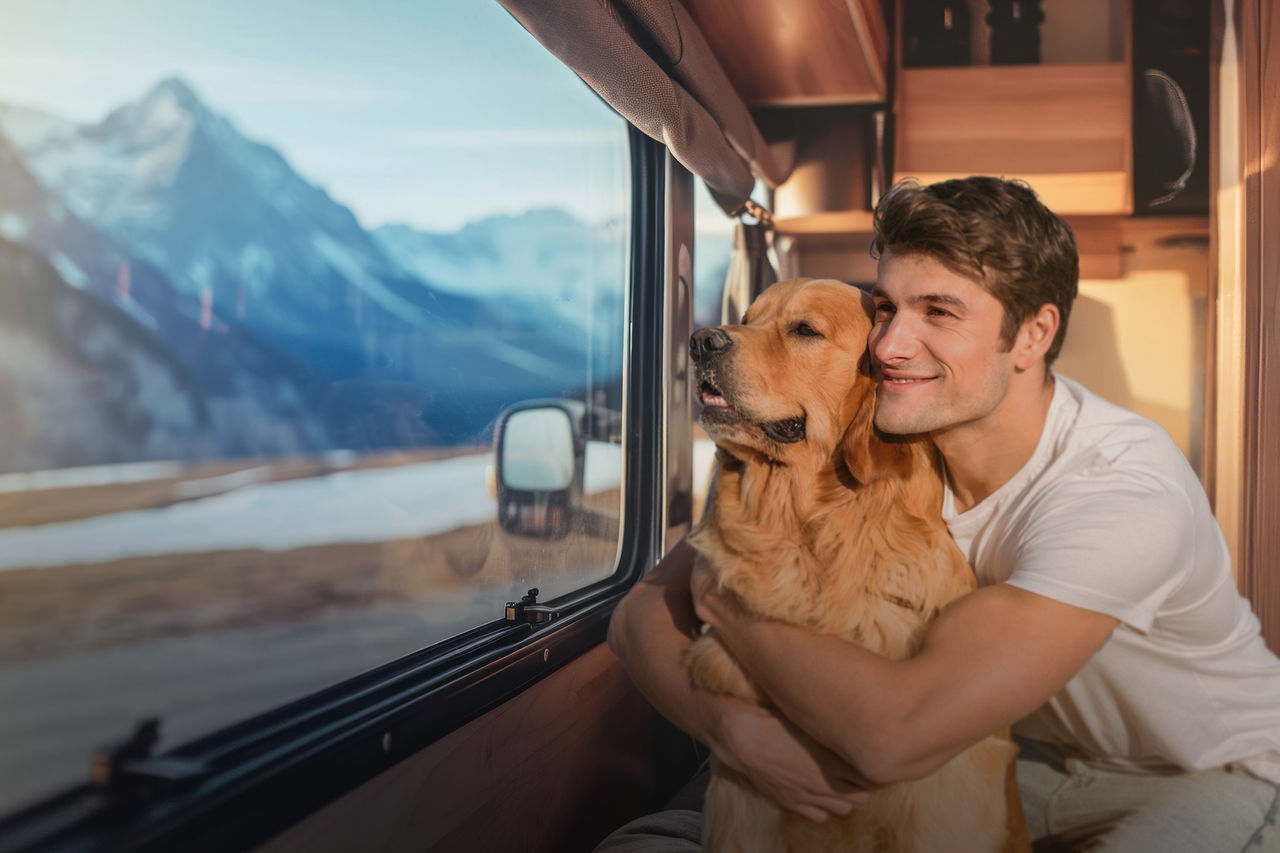 Motorhome interior with occupant and dog by window, illustrating cabin climate comfort and quiet auxiliary air heating solutions as a Webasto system for RVs.