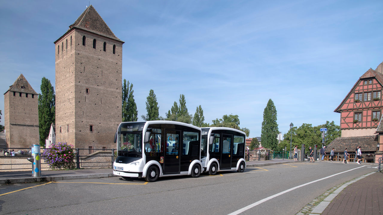 Autonomous electric shuttle at a historic urban stop for reference stories, highlighting Webasto vehicle electrification, modular battery and thermal systems.