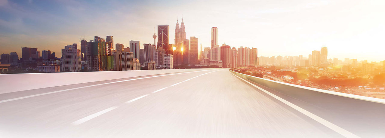 Hero header for Vehicle Solutions: urban skyline and open highway conveying Webasto as a system partner for future-ready vehicle electrification and thermal management.