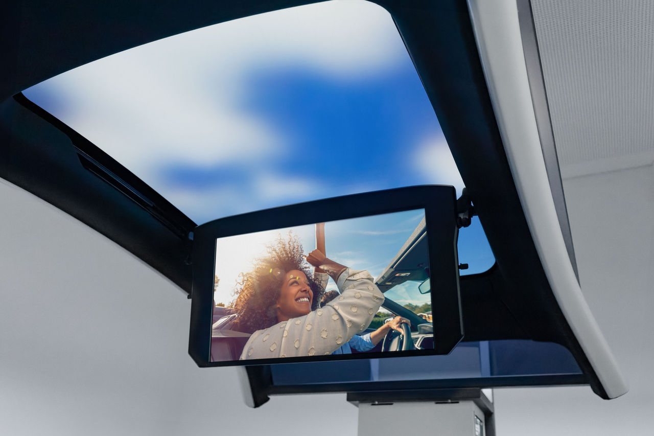 Panoramic glass roof with flip-down rear entertainment monitor for passenger cars, header visual for roof systems pages showcasing Webasto system integration.
