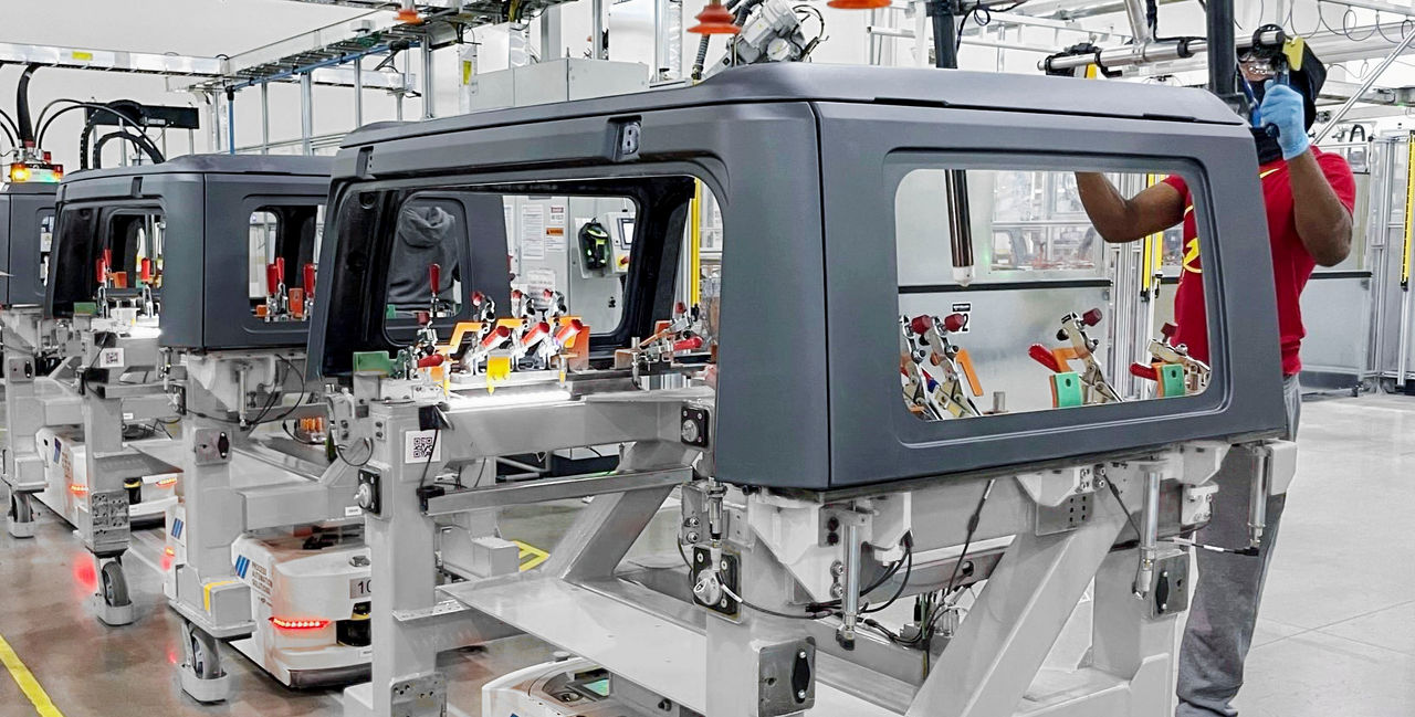 Webasto system partner — roof-system production line showcasing hardtop module assembly with AGV transport and operator stations for Roof Systems.