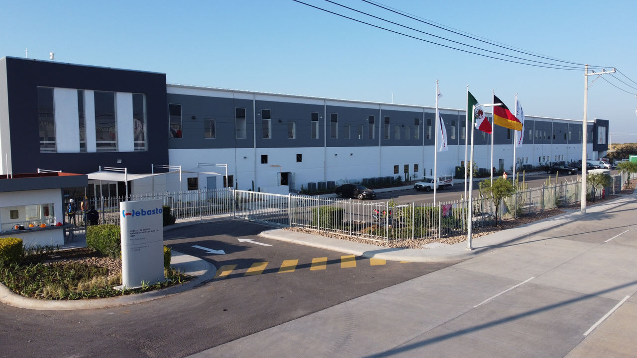 Webasto Mexico production facility exterior with corporate and national flags, illustrating Webasto's global manufacturing footprint and system partner role.