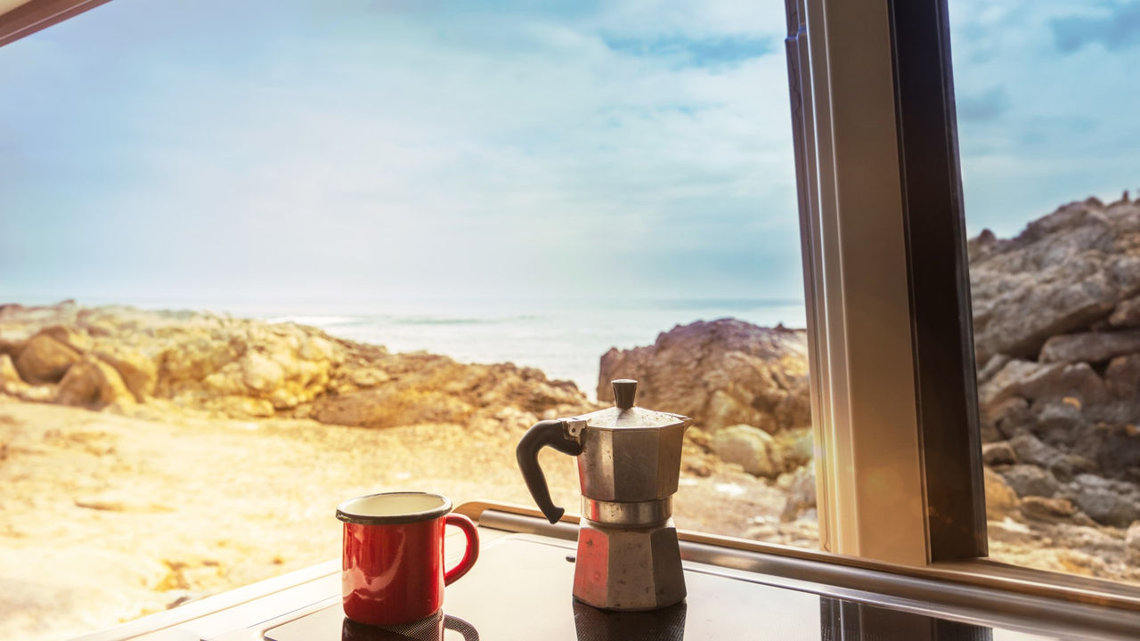 Cup and coffeemaker on cooker in recreational vehicle
