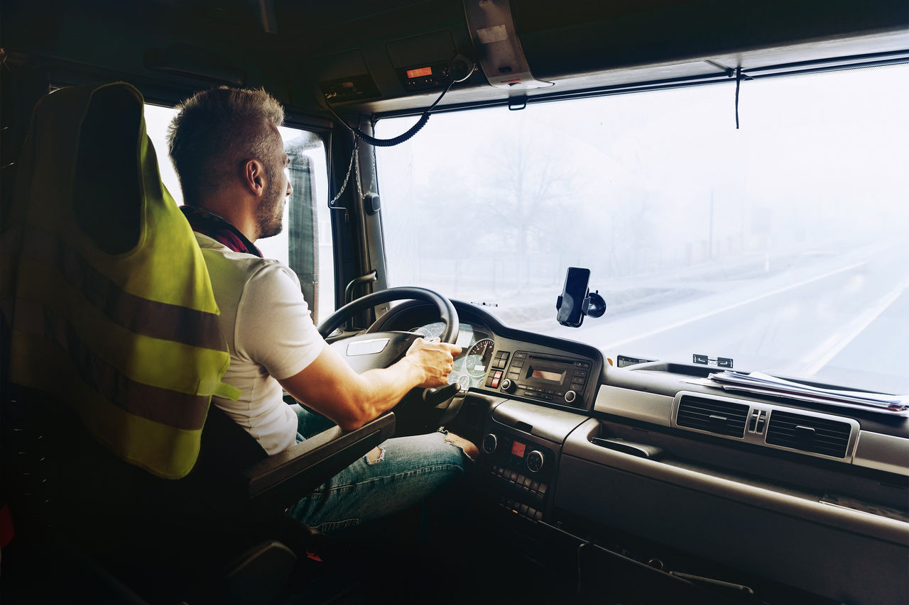 Truck driver in cab with on-board water heater and climate controls, illustrating Webasto as system partner for thermal management in commercial vehicles.