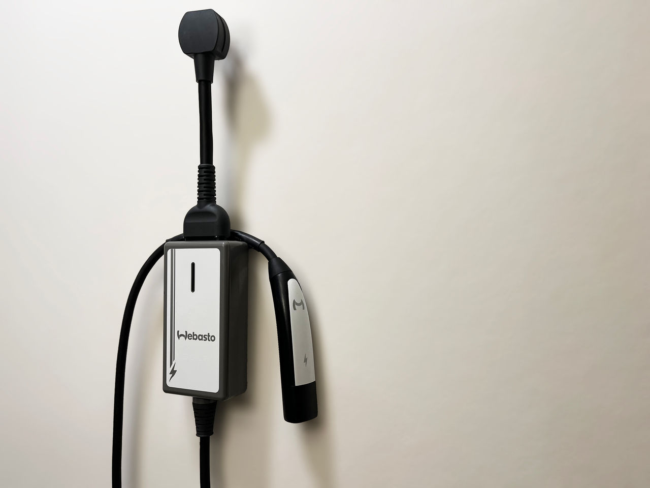 Wall-mounted Webasto system home EV charging unit with integrated cable and Type 2 connector, featured on products & solutions › vehicle electrification page.
