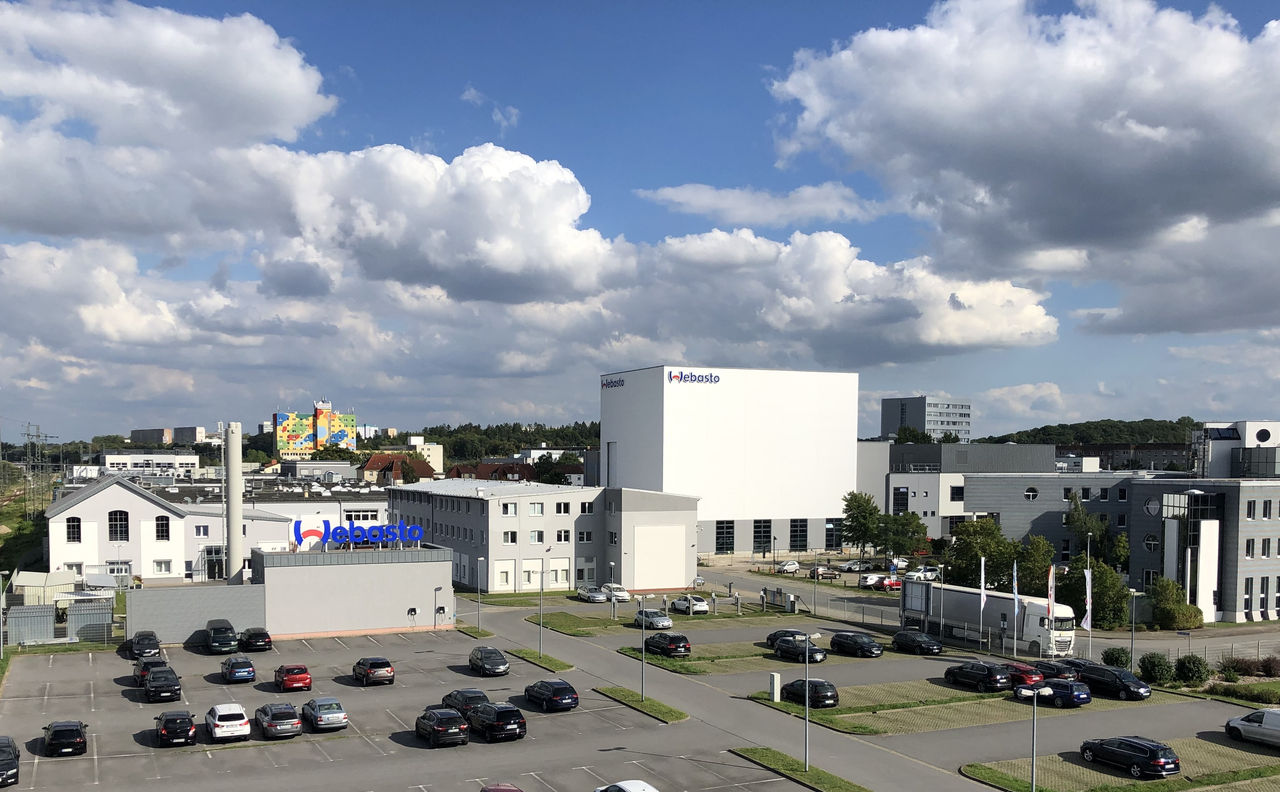 Webasto manufacturing campus with branded buildings and logistics area, highlighting Webasto’s systems-partner role in vehicle electrification and roof systems.