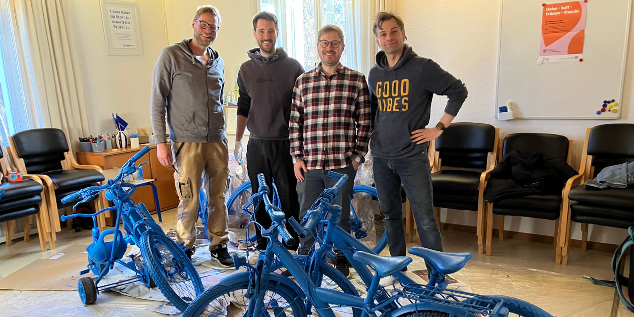 Webasto system partner volunteers refurbishing and painting children's bicycles for local charity, showcasing corporate social responsibility and community.